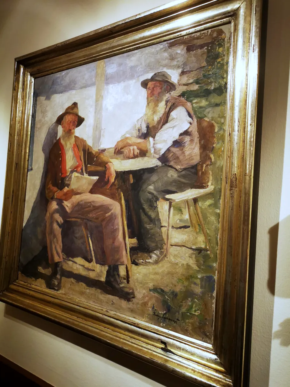 Gemälde zweier Bauern am Tisch in breitem Silberrahmen