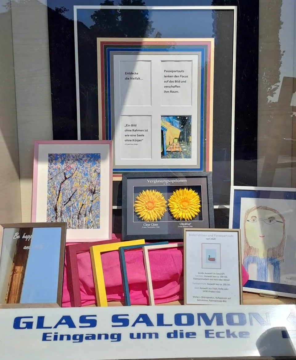 Schaufenster von Glas Salomon mit Rahmenmustern und Hinweis „Eingang um die Ecke“